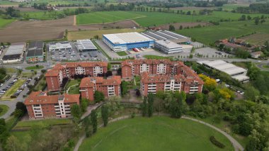 Konut kompleksi ve sanayi bölgesinde hava manzaralı evler. San Giuliano Milano şehrinin en iyi manzarası. Bir bahar günü evlerin ve sokakların insansız hava aracı görüntüsü. Milan, Lombardiya, İtalya. 