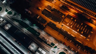 Gece otobüs durağının ve yol trafiğinin en üst görüntüsü. Arabanın üstü aşağı bakıyor.. 