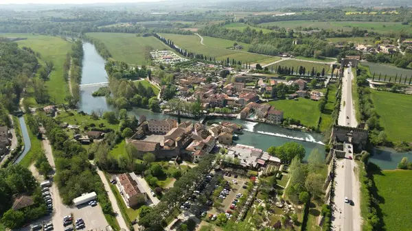 Nehirdeki güzel İtalyan köyü. İtalya, Veneto 'daki Garda Gölü' nün güneyindeki Borghetto Konsolosu Mincio. Küçük ortaçağ köyünün insansız hava aracı görüntüleri.. 