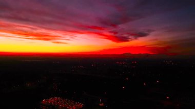 Şehrin üst manzarasında kırmızı gün batımı. İtalya, Milan