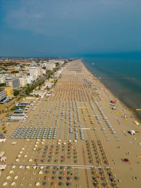 Rimini manzaralı bir plaj. Adriyatik Denizi kıyısı. Şemsiyeli ve güneşli uzun sahil manzarası. Yüksek kalite fotoğraf