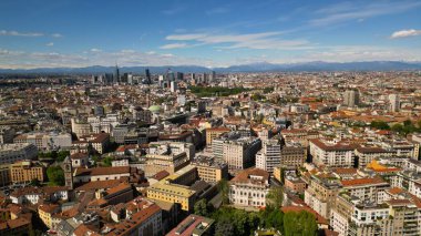 Gökdelenler şehrin siluetinde. Milano şehir manzarası mavi gökyüzünün arka planına karşı, yukarıdan güneşli hava manzarası. 