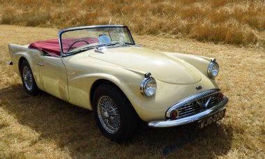 Little Gransden, CAMBRIDGESHIRE, İngiltere - 08 AĞUSTOS 2022: Çimlerin üzerine park edilmiş klasik Cream Daimler Dart Otomobili.