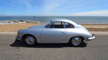 FELIXSTOWE, SUFFOLK, ENGLAND - MAYIS 05, 2024: Klasik Porsche 356 Coupe otomobili plaj ve deniz manzaralı deniz gezintisi.