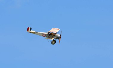 ICKWELL, BEDFORDSHIRE, ENGLAND - MAY 12, 2024:  Replica Bristol Scout C  biplane in flight blue sky  clipart