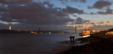 Gece zaman Tagus Nehri Panoraması Ponte 25 de Abril ve anıt Cristo Rei Lizbon Portekiz