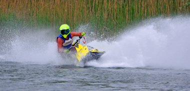 WYBOSTON, BEDFORDSHIRE, İNGİLTAN - MAYIS 024, 2024: Jet Ski yarışçısı hız konusunda virajda çok fazla sprey üretiyor