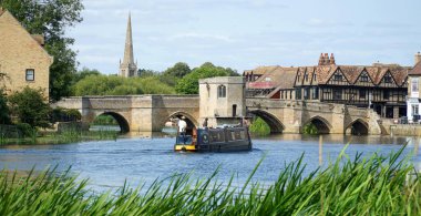 St. Ives, CAMBRIDGESHIRE, İngiltere 17 Ağustos 2024: St. Ives Cambridgeshire 'daki tarihi köprüye yaklaşan dar tekne
