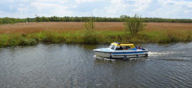 HORNING, NORFOLK, ENGLAND - 10 Mayıs 2018: Horning yakınlarındaki Bure nehrinde gezinen küçük bir zevk teknesi, Norfolk Hatunları.