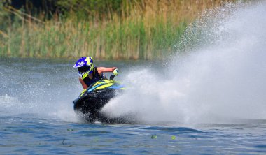 WYBOSTON, BEDFORDSHIRE, İNGİLTAN - MAYIS 024, 2024: Jet Ski yarışçısı hız konusunda virajda çok fazla sprey üretiyor