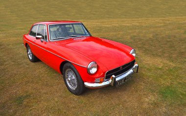 UPPER DEAN, BEDFORDSHIRE, İngiltere - 07 Eylül 2024: Çimlerin üzerine park edilen klasik Red MGB GT