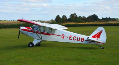 ICKWELL, BEDFORDSHIRE, ENGLAND -  SEPTEMBER 17, 2024:  Piper PA-18 Super Cub G-ECUB aircraft on airstrip clipart