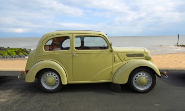FELIXSTOWE, SUFFOLK, ENGLAND - MAYIS 05, 2019: Arka planda deniz kenarında park etmiş klasik Ford Anglia