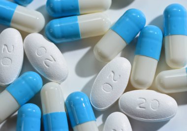 Atorvastatin Film Kaplamalı Tabletler 20 mg ve Omeprazole kapsülleri beyaz zemin üzerinde mavi ve beyaz gruplar
