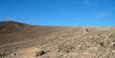 Rim of extinct volcano on Lanzarote with figures in distance clipart