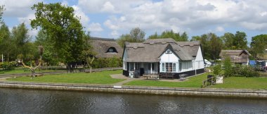 HORNING, NORFOLK, ENGLAND - MAY 10, 2018:  Luxury  Property on the banks of the river Bure at Horning Norfolk England. clipart