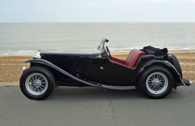 FELIXSTOWE, SUFFOLK. ENGLAND - MAYIS 07, 2017: Arka planda deniz kenarında park etmiş klasik Black MG motorlu araç.