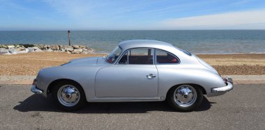 FELIXSTOWE, SUFFOLK, ENGLAND - MAYIS 05, 2024: Arka planda deniz kenarında park edilmiş klasik Gümüş Porsche 356