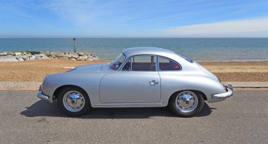 FELIXSTOWE, SUFFOLK, ENGLAND - MAYIS 05, 2024: Klasik Porsche 356 Coupe otomobili plaj ve deniz manzaralı deniz gezintisi.
