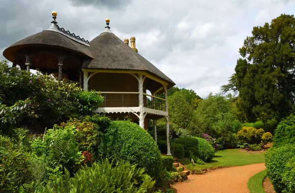 CKwell, BEDFORFDSHIRE, İNGİLTAN - 30 MAYIS 2025: İsviçre tyle yazlık evi büyük çalılar ve ağaçlarla dolu bahçe