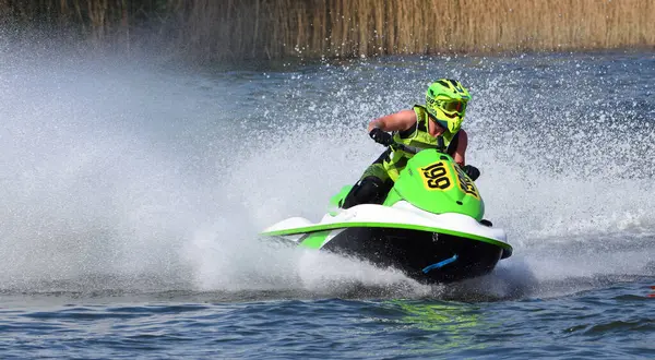 WYBOSTON, BEDFORDSHIRE, ENGLAND - 12 NİSAN 2025: Jet Ski yarışçısı hız konusunda virajda bir sürü sprey yapıyor 