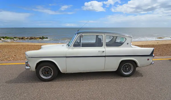 FELIXSTOWE, SUFFOLK, ENGLAND - MAYIS 04, 2025: Klasik Ford Anglia 105E arka plandaki sahil ve deniz kenarına park edilmiş