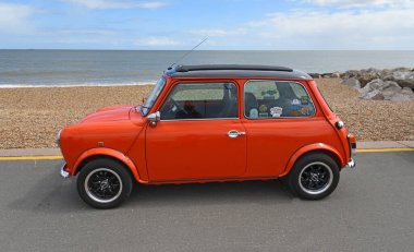 FELIXSTOWE, SUFFOLK, ENGLAND - MAYIS 04, 2025: Deniz kenarında park etmiş klasik Orage renkli Mini Car ve arka planda