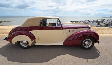FELIXSTOWE, SUFFOLK, ENGLAND - MAYIS 04, 2025: Klasik Alvis TA 21 Drophead Coupe Seafront Gezinti Sahili 'ne ve denize park etmiş arka planda