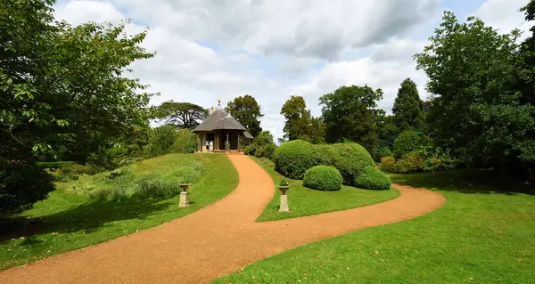 Bahçe yolu geniş çalılar bahçe evi ve ağaçlarla dolu.