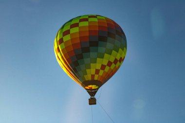 Mavi gökyüzünde uçan renkli sıcak hava balonu