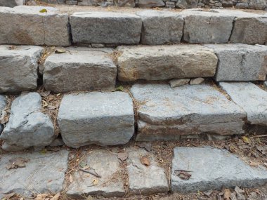 Eski taş basamaklar. Gandhara harabeleri. Taxla 'da kalıntılar bulundu. Taşlar adım atmak için hizalandı. Taş parçalarından eski eğimli basamaklar. Telif hakkı bedava. Kullanmaya hazır.