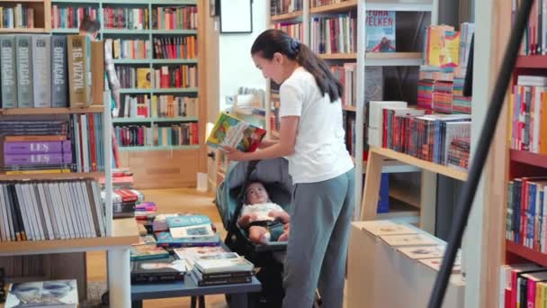 Joven Madre Muestra Libro Colores Bebé Una Librería Imágenes Alta — Vídeos de Stock