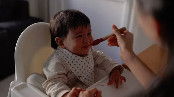 엄마가 아기에게 먹이는 뒷모습 어린아이는 의자에 숟가락으로 식사를 고품질 — 스톡 사진