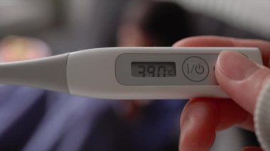 Termometrenin yakın görüntüsü bir çocuğun bulanık arka planına karşı yüksek ateşi gösteriyor. Yüksek kalite 4k görüntü