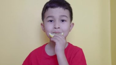 Bir çocuğun tadı bir parça limon, kırışıklıklar ve somurtuyor. Yüksek kalite fotoğraf