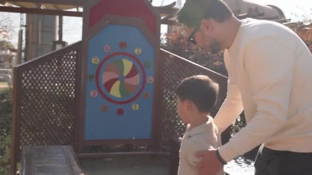 幸せな愛情のお父さんは ターゲットにリングを投げるために彼の小さな息子を教えています 高品質4K映像 — ストック動画