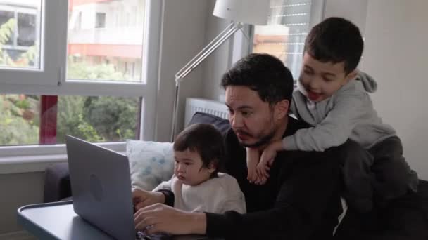 幼い息子を手に家で働き 6歳の息子が抱きかかえようとする青年 遠隔作業だ 高品質4K映像 — ストック動画