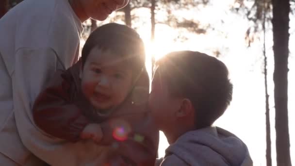 一个慈祥的母亲摇动着一个婴儿 男孩在大自然中温柔地亲吻婴儿 高质量的4K镜头 — 图库视频影像