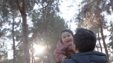Babam bebeği ağaçların önüne fırlattı. Aşağıdan bak. Yüksek kalite 4k görüntü