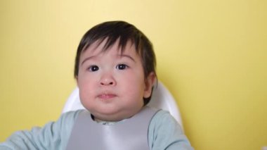 Anne bebeğini kaşıkla besliyor. Tamamlayıcı gıdaların tanıtımı, iyi beslenme, bebek maması yüksek kalite 4K görüntü