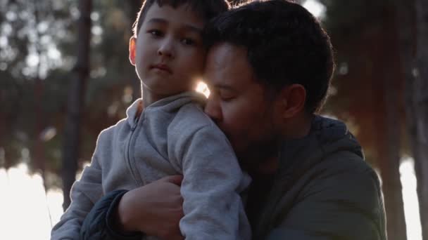 一个慈爱的父亲牵着他的儿子 在大自然中温柔地吻着他 — 图库视频影像