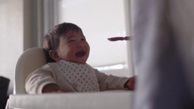 Bebeğin yandan görünüşü, annesinin ona verdiği yemekleri yemek ve gülmek. Yüksek kalite 4k görüntü