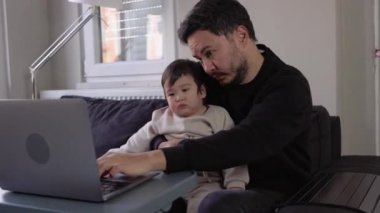 İki oğlu yoluna çıkarken genç bir adam çalışmaya çalışıyor. Uzaktan kumanda. Yüksek kalite 4k görüntü