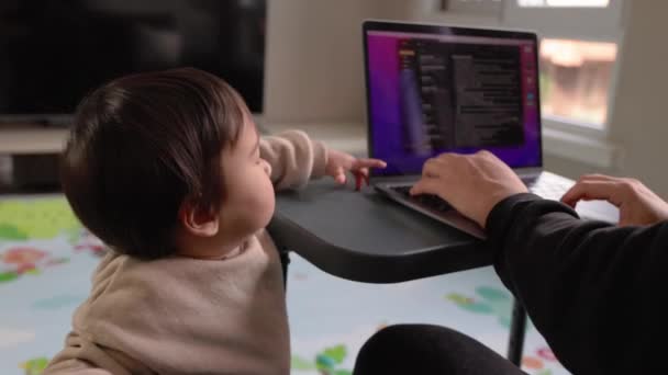 Mężczyzna Pracuje Laptopie Domu Kanapie Podczas Gdy Jego Roczne Dziecko — Wideo stockowe