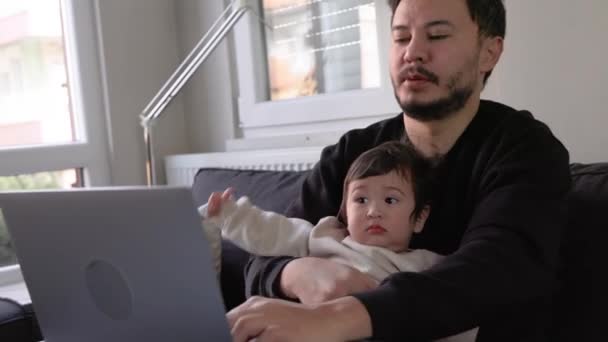 Egy Fiatal Elfoglalt Ember Aki Laptopján Dolgozik Otthon Tartja Fiát — Stock videók