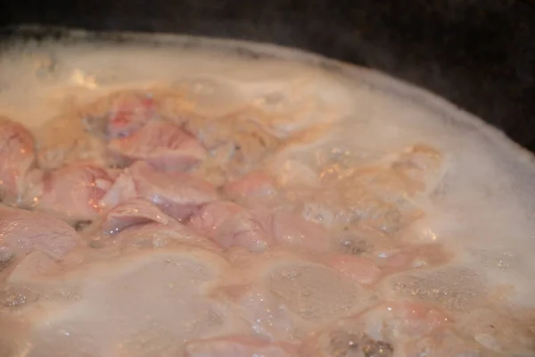 大きな鍋で肉を調理 水の表面の泡は — ストック写真