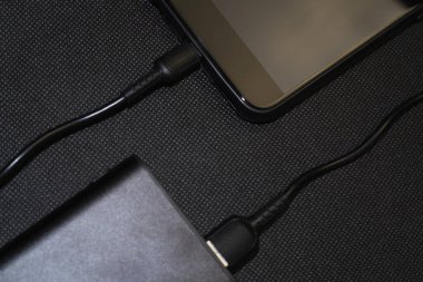 Güç bankasını şarj ediyorum. Şarj cep telefonu ya da akıllı telefon bataryası için beyaz USB kablosu olan taşınabilir güç bankası. Üst görünümde modern teknoloji kavramı