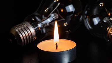 Arka planda elektrik lambası ve mum var. Parlayan lamba ve mum. Elektrik kesintisi yok. Yüksek elektrik fiyatları. Elektrik tasarrufu.