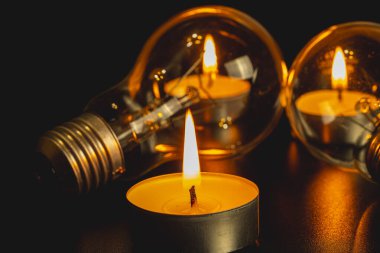 Arka planda elektrik lambası ve mum var. Parlayan lamba ve mum. Elektrik kesintisi yok. Yüksek elektrik fiyatları. Elektrik tasarrufu.