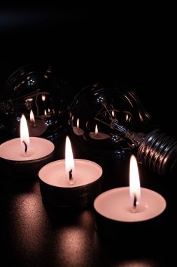 Arka planda elektrik lambası ve mum var. Parlayan lamba ve mum. Elektrik kesintisi yok. Yüksek elektrik fiyatları. Elektrik tasarrufu.